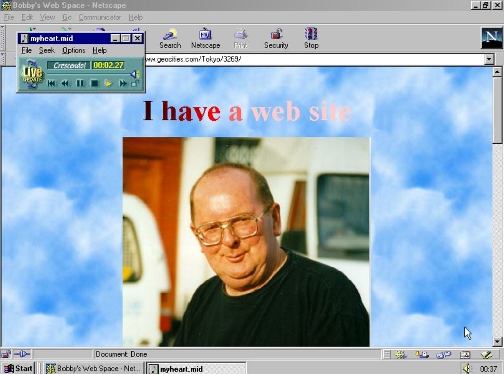Screenshot of a geociti3s pagem there is a bluesky in the background and a headshot of a bald man with glasses. The text says "I have a web site."