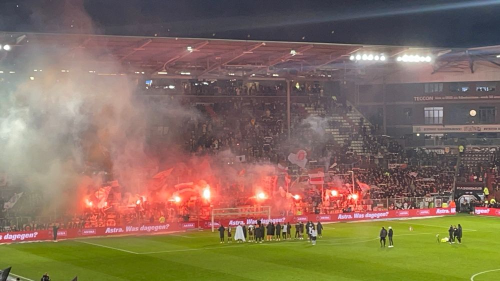 St. Pauli-Spieler feiern mit der in pyrotechnisches Licht gehüllten Südkurve den 1:0-Sieg über Hoffenheim (14.03.2025)