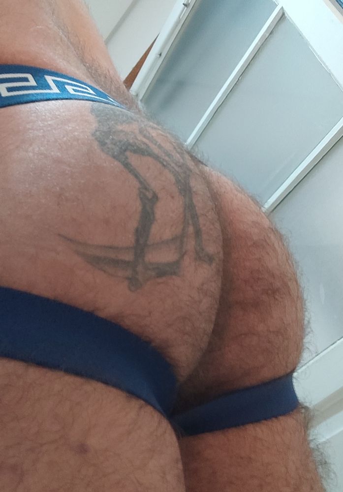 My tattooed hairy ass in a jockstrap with blue stripes.