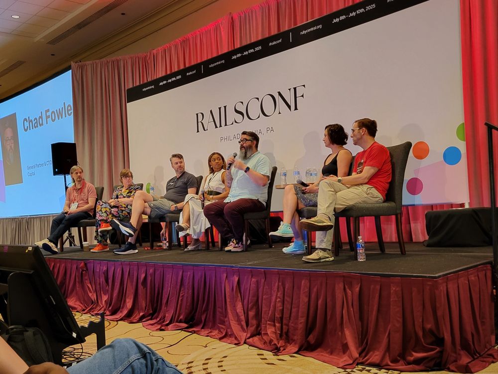 Chad Fowler describes how we became involved in the Rails community while the panel looks on. 