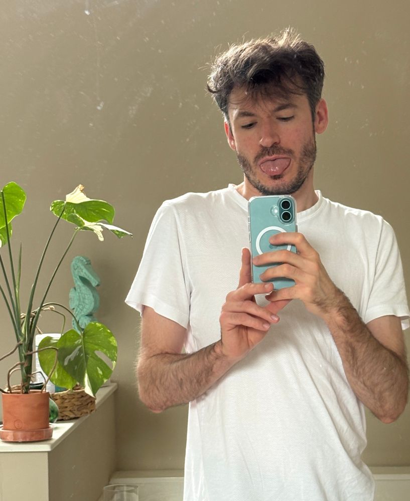 sticking my tongue out while taking a selfie in the mirror