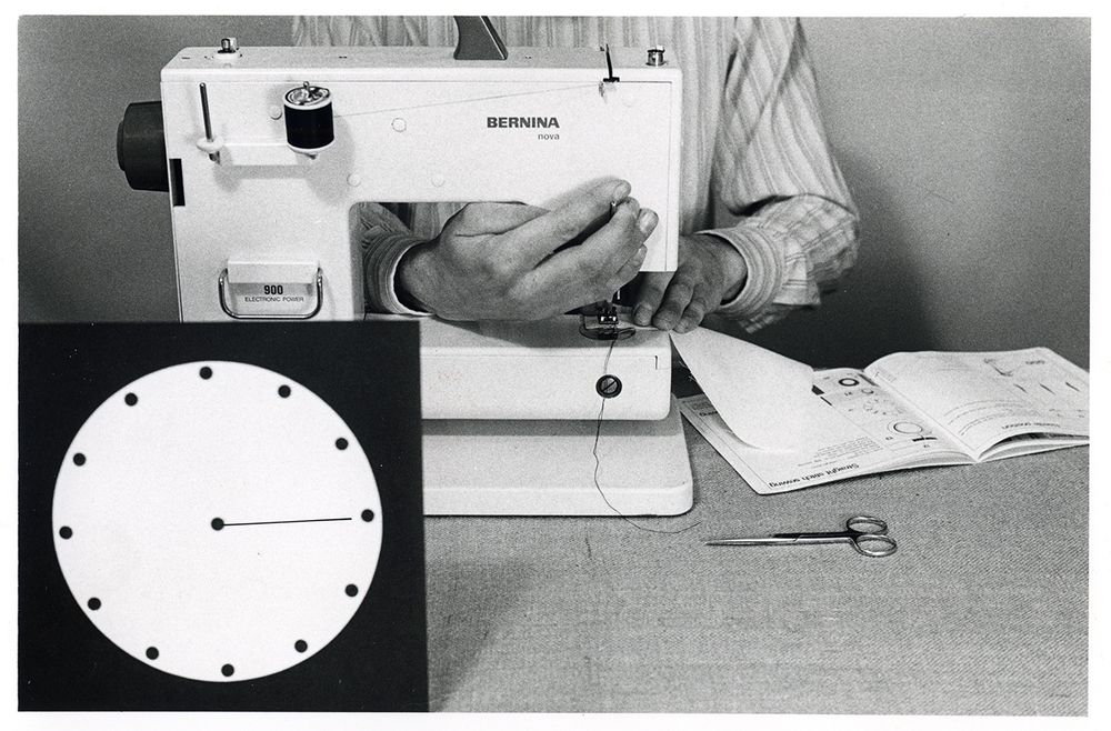 black and white photograph of a person using a sewing machine 