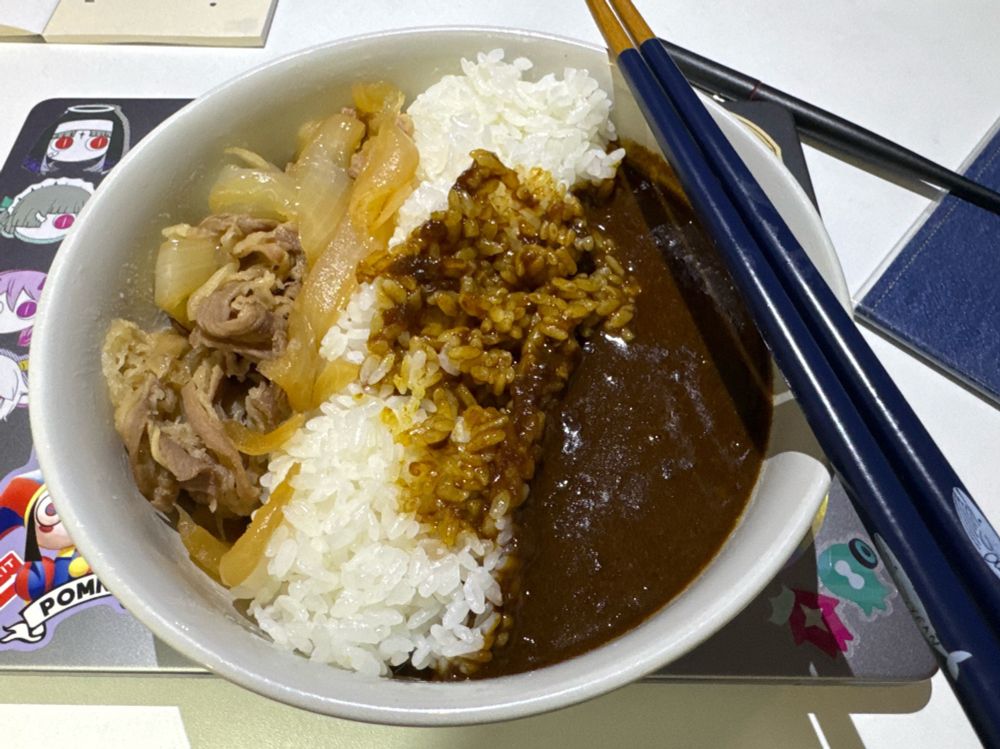 两侧分别是咖喱和牛肉饭，中间由米饭隔开的一碗盖饭。