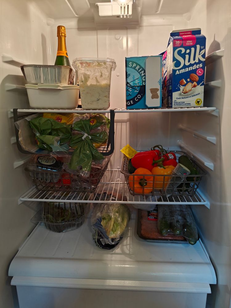 After photos of my fridge with produce in baskets that can be pulled out easily, and large items on the top shelf next to the almond milk. 