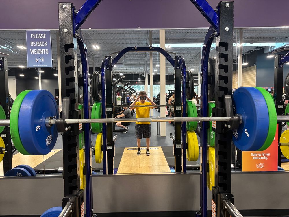 A squat rack with a barbell loaded to 185 
