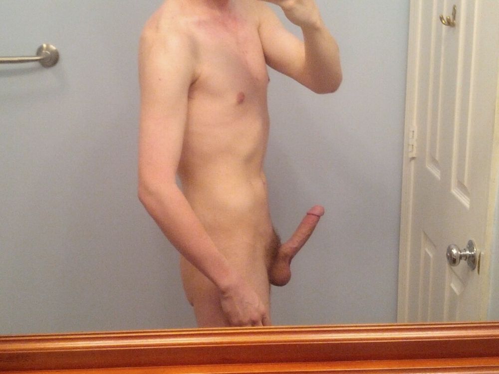 Me, 19, against a light blue wall, standing somewhere between profile and 3/4, naked with a boner. I have acne over my upper chest. The picture is angled to cut me off at the neck.