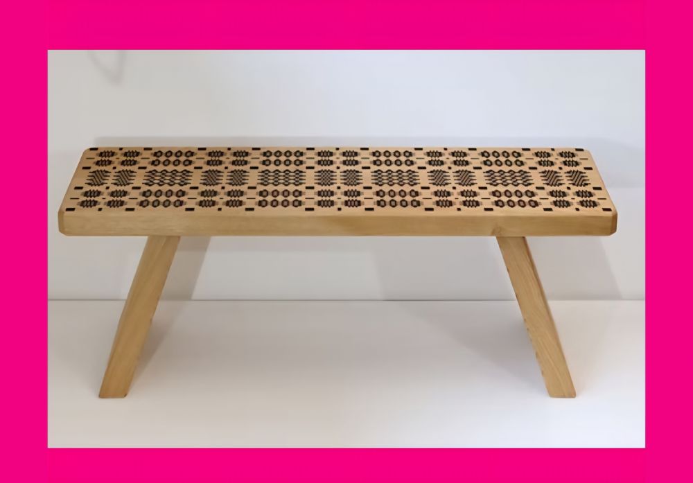 Photo of long chunky wooden bench with bench top showing a geometric pattern.