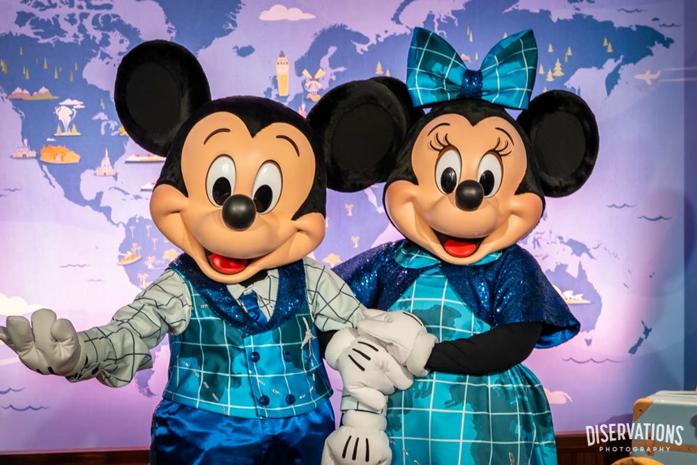 Mickey and Minnie wearing vibrant blue travel-themed outfits