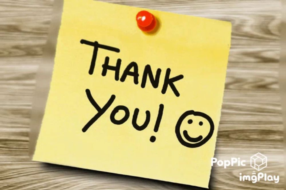 a yellow sticky note that says thank you is pinned to a wooden surface