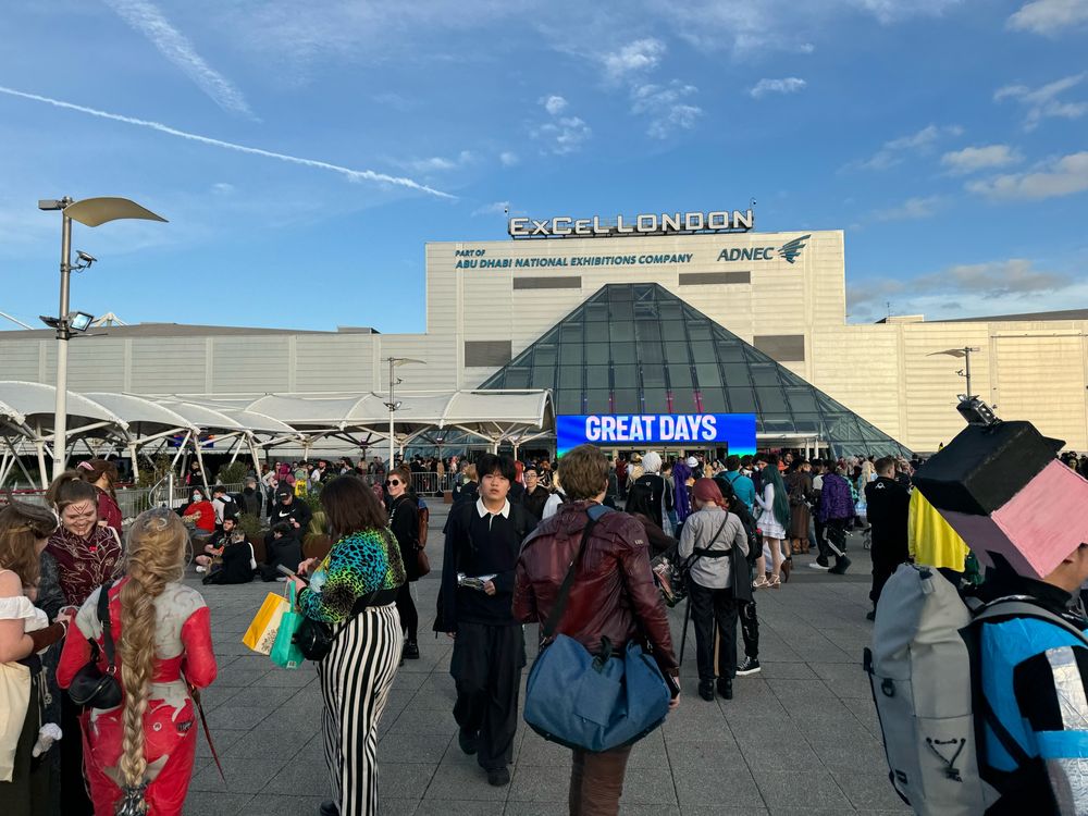Shot of the Excel London convention centre, with numerous cosplayers walking towards the entrance.