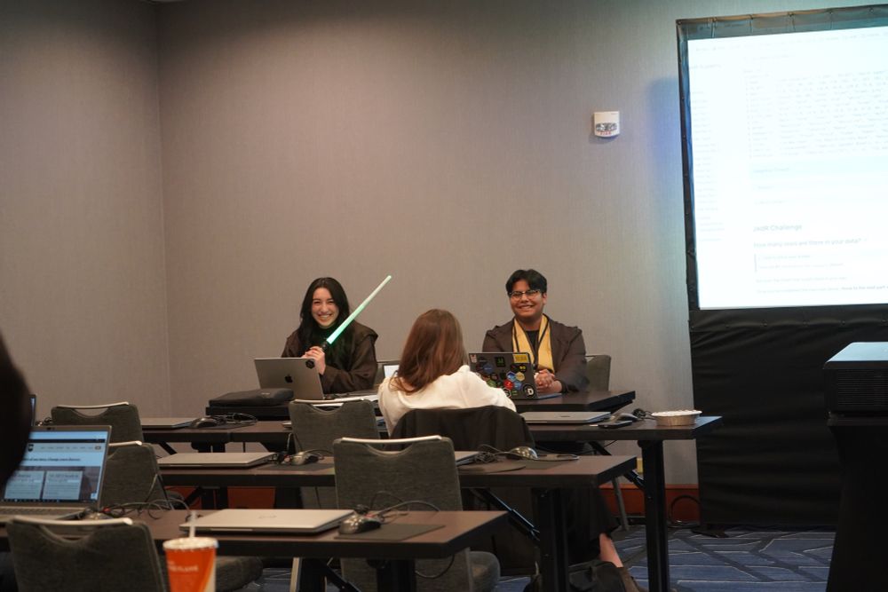 Classroom showing speakers in front in Jedi costumes and one is holding a light saber 