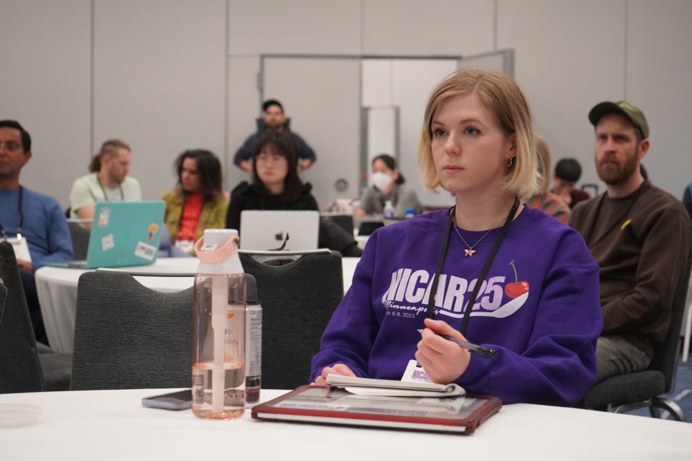 Attendees in sessions listening with person in front wearing purple NICAR25 sweatshirt