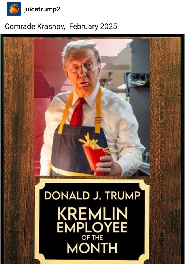Image shows a photo of Donald J Trump, wearing an apron, holding a package of french fries, placed above a small plaque that says Kremlin employee of the month.