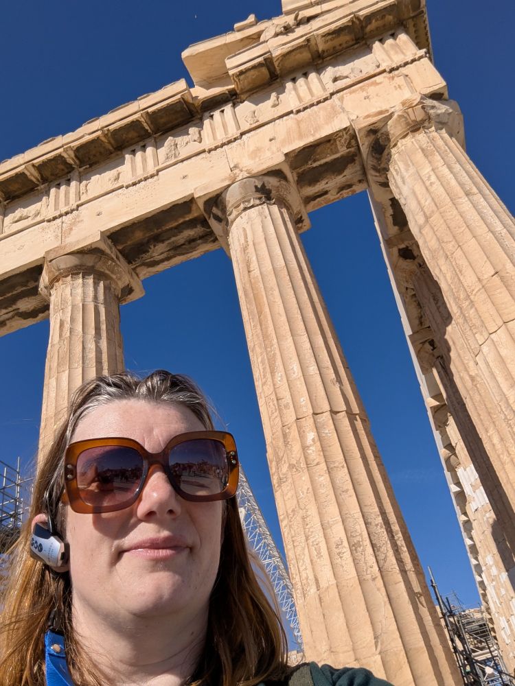 Culliope stands in front of three columns of the Parthenon 