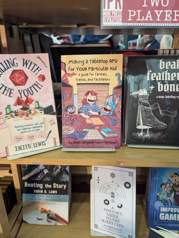 Making a tabletop RPG for your particular kid by Steph Campbell on a shelf with a lot of other TTRPG books