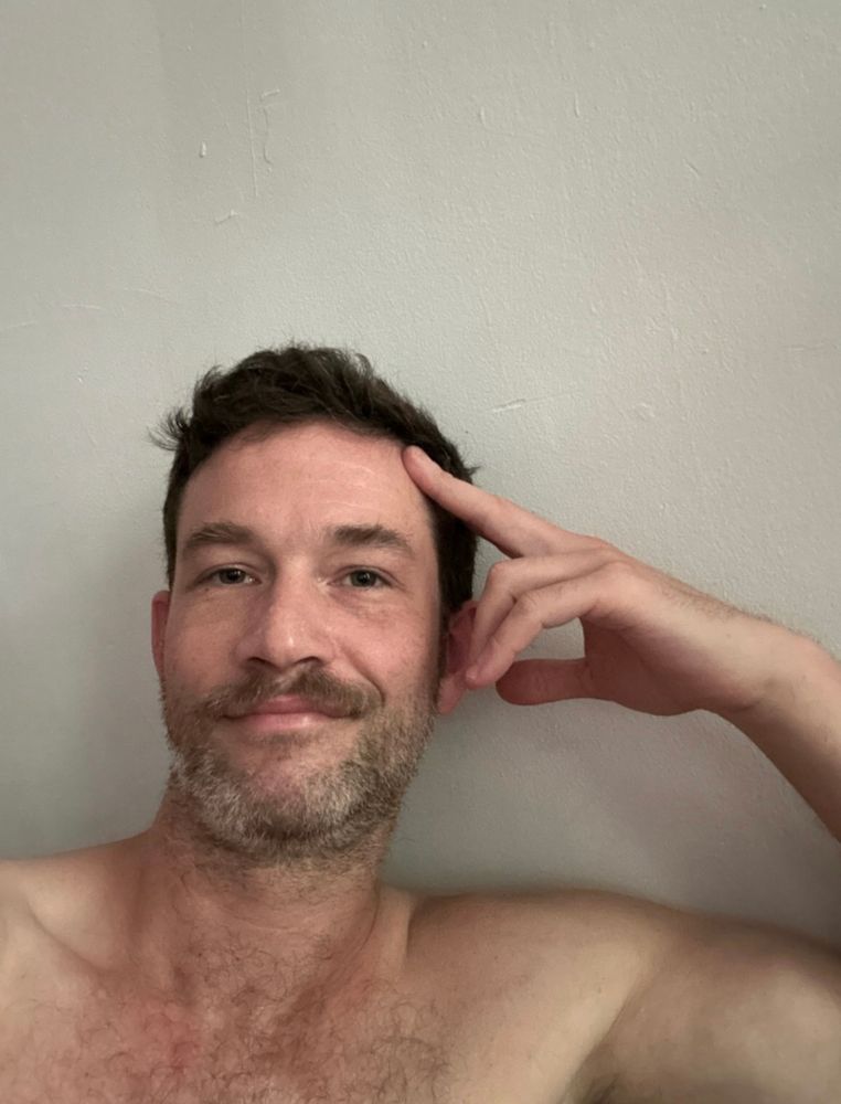 a selfie of a guy named Ian without glasses or a shirt