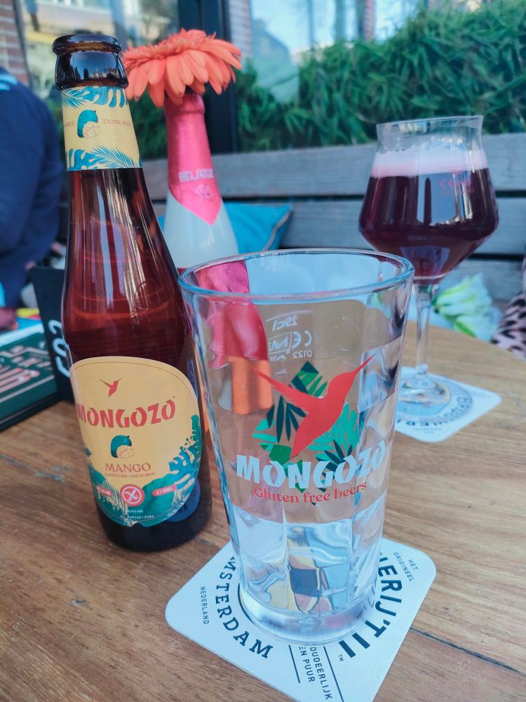Flesje Mango bier en een glas Kriek met een gezellig bloemetje op de tafel
