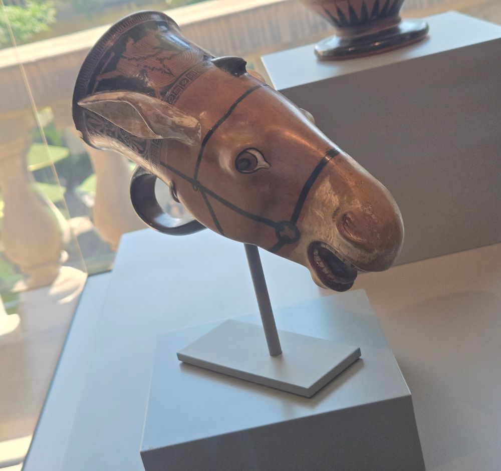 ancient donkey shaped drinking cup on a display pole
