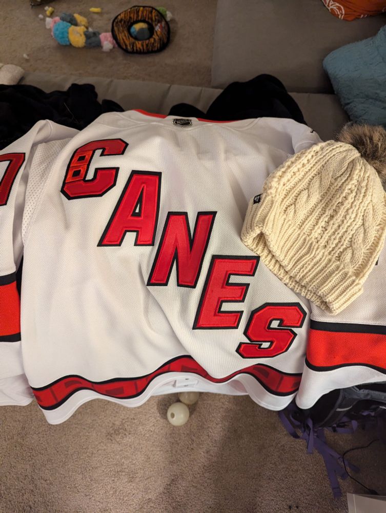 White hurricanes jersey and white beanie 