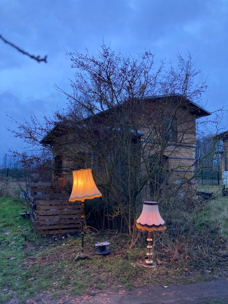 Bahnhofshäuschen in der Dämmerung.
Mit alten Stehlampen davor.