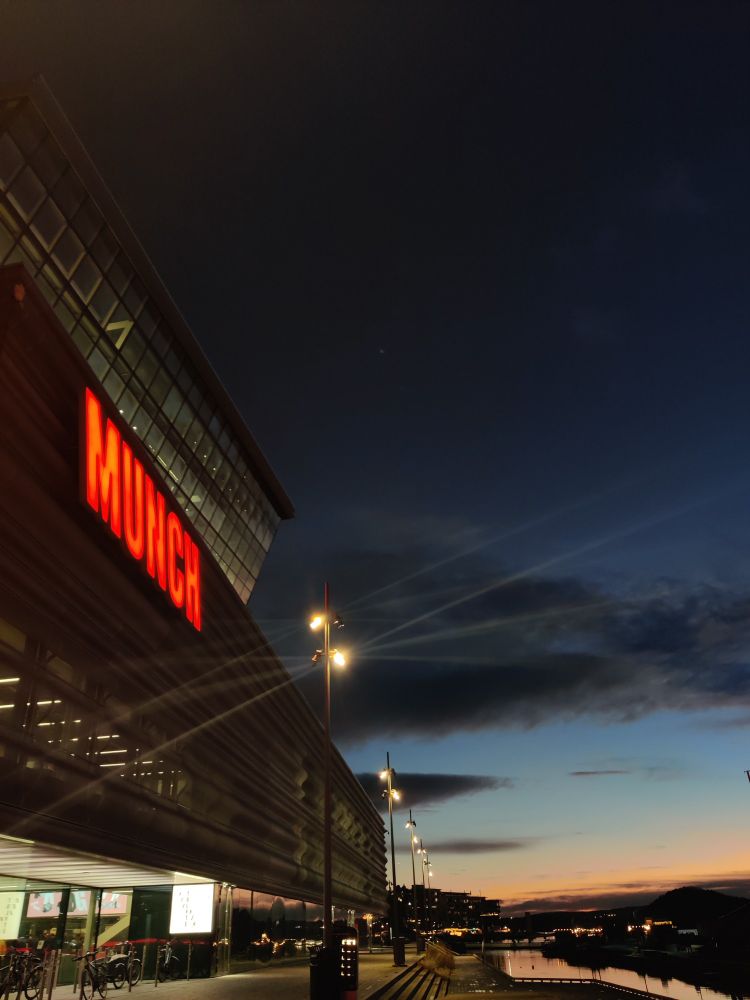 Image shows the MUNCH museum building in front of big blue sky