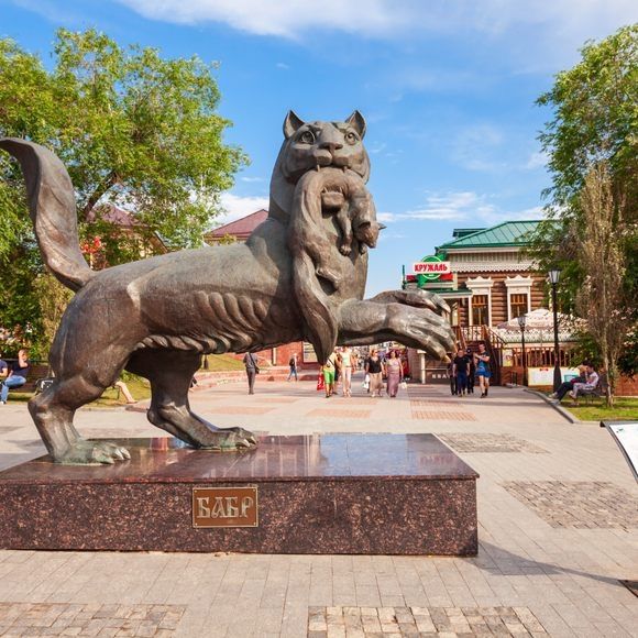 Photo of a statue of a Babr, showing a large cat-like animal with webbed feet and a flattened tail and a dead sable in its mouth. 
Statue by Natalia Bakut (sculptor) and Olga Smirnova (architect)

 