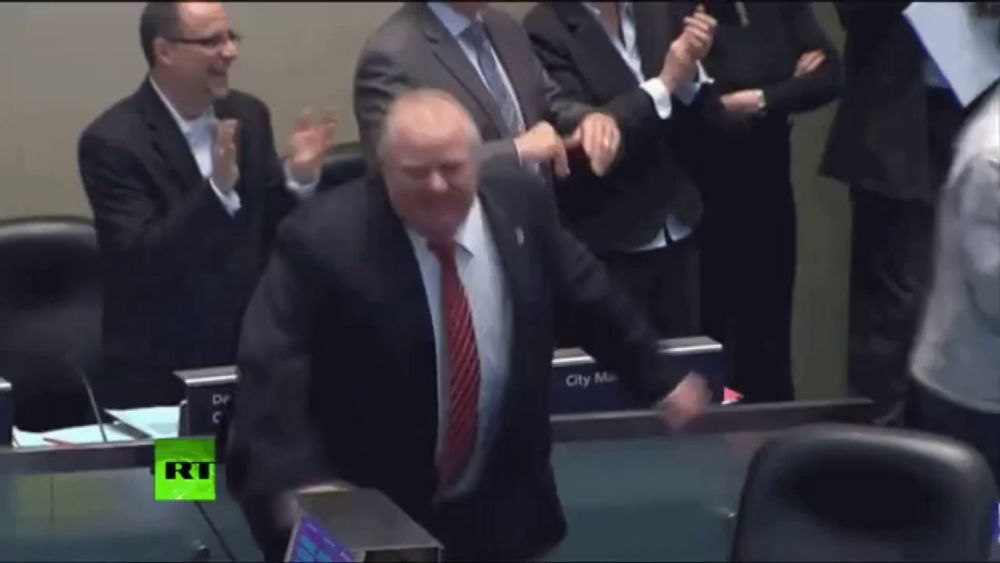 a man in a suit and tie is dancing in front of a rt sign