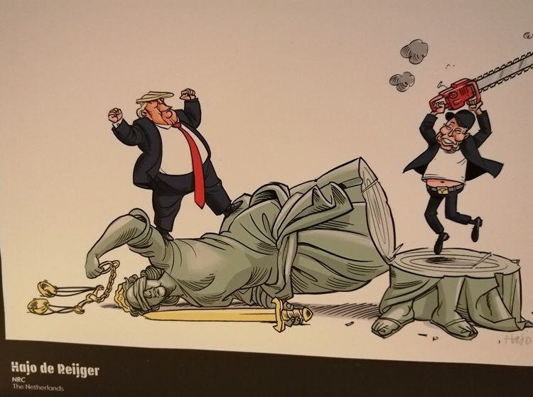 Cartoon showing Elon Musk and Donald Trump jubilant on top of a fallen Liberty statue