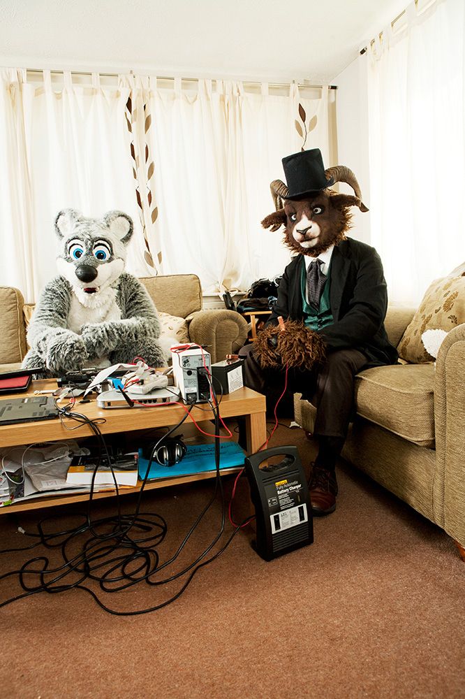 A North American sea otter and a sheep soldering in their front room. From At Home With The Furries, a project by photographer Tom Broadbent