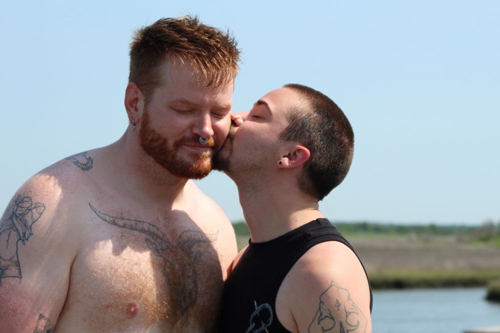 big redheaded himbo receives a cheek kiss from trans twink