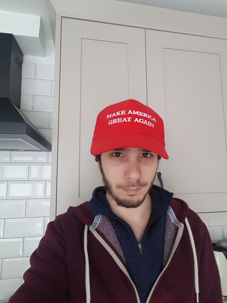 a picture of adam langleben wearing a red MAGA hat in a kitchen