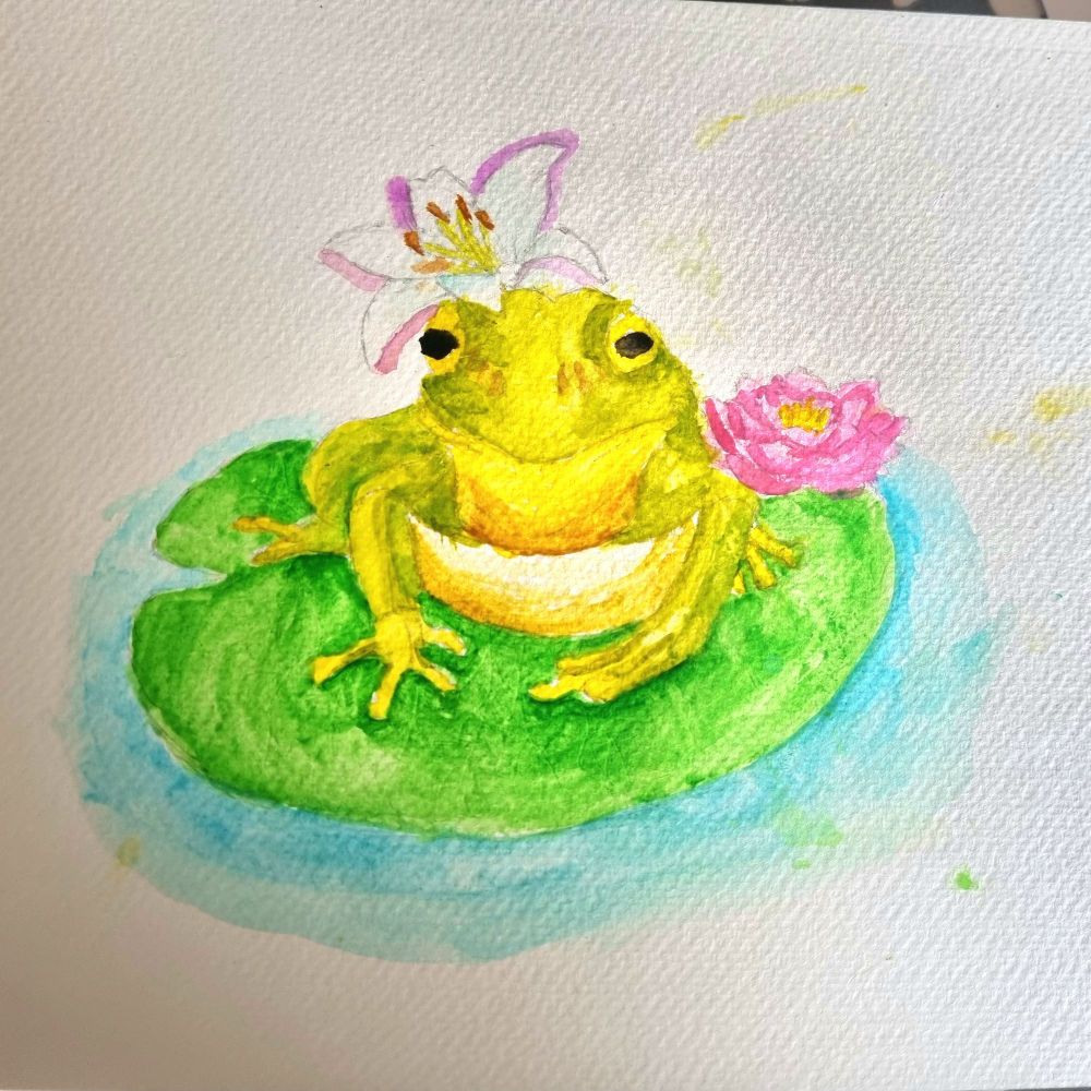 Watercolour painting of a green frog with a yellow belly sat on a lilypad. A pink waterlily sits beside it. A white lily is draped across its head