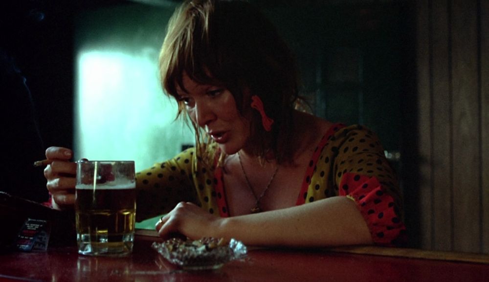 A woman sits at the bar with a glass of beer and a cigarette. Susan Tyrell in Fat City (1972) dir. John Huston. One of the greatest performances of all time, imo.
