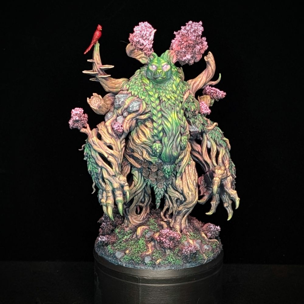 A painted miniature of an elemental bear spirit rendered in pinks, greens, and warm browns. A bright red cardinal is perched on a growth above the spirit's right shoulder.