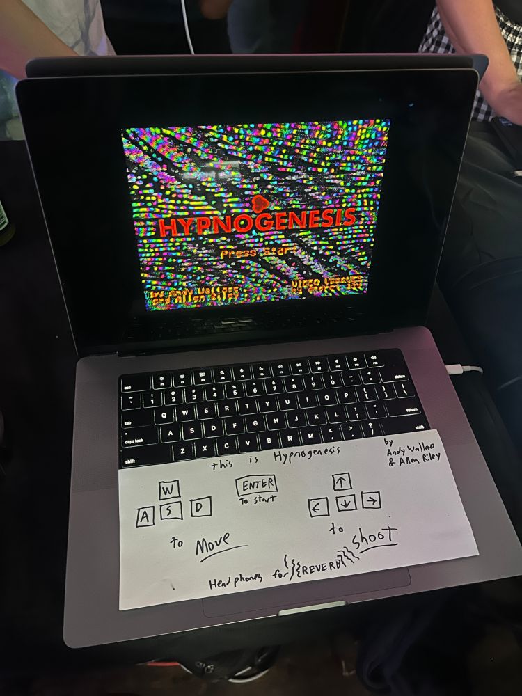 laptop with the hypnogenesis title screen and a hand-written piece of paper explaining the controls