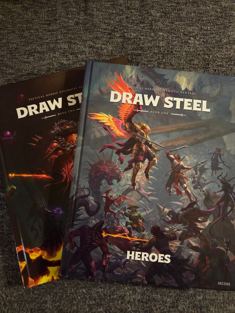 Both Draw Steel core rule books stacked on one another.