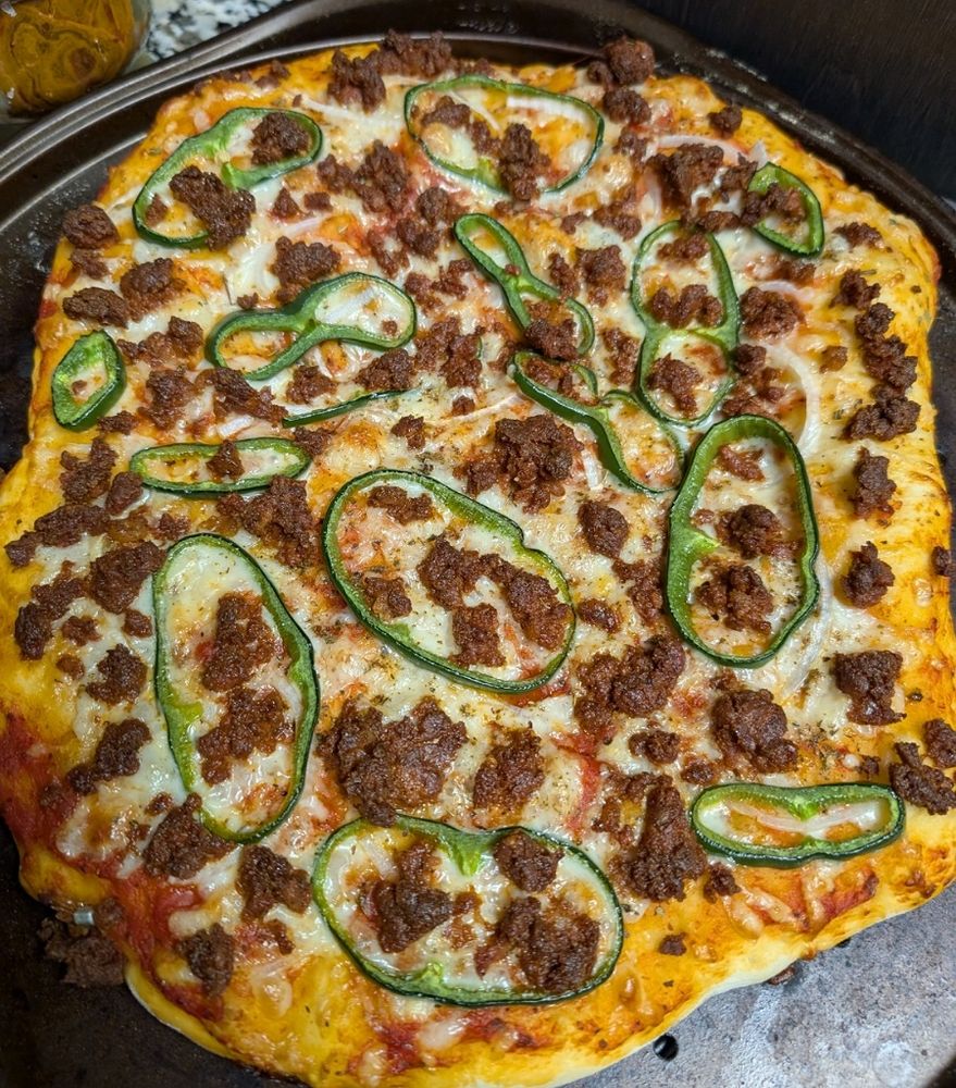 A picture of the pizza described in the text on a perforated pizza pan.