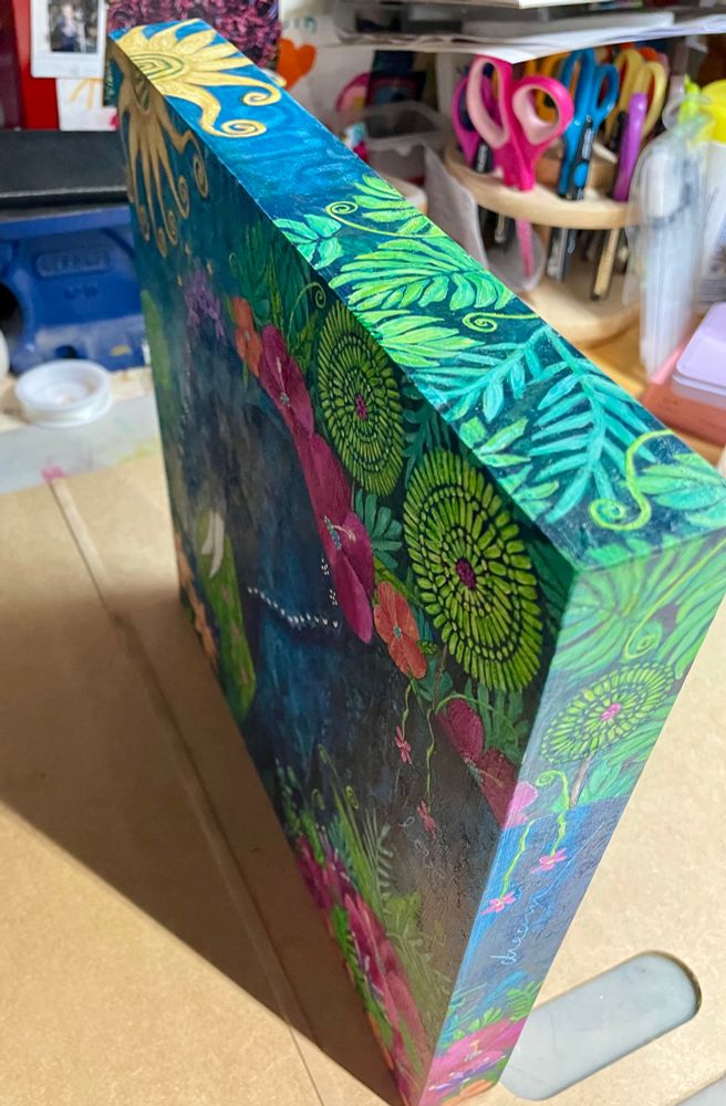 Top view of a colourful acrylic painting of a tropical scene.