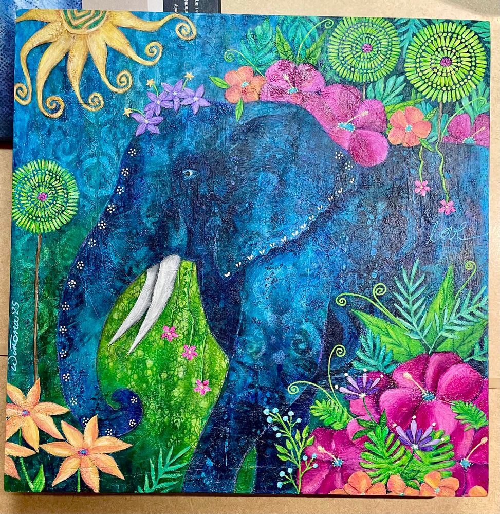 Colourful acrylic painting features a blue elephant walking through a garden of pinwheel trees, bright magenta yellow and peach tropical flowers, and various bright green plants. It wears a crown of small purple flowers. There is a swirly sun in the upper left corner. 
Available soon as prints and on other various products at: 
linktr.ee/sunshyneart