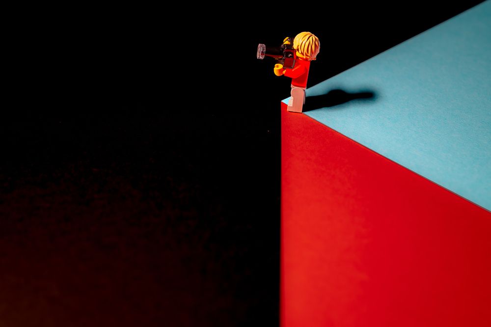 Eine Lego Figur Fotograf, der scheinbar an einem Abgrund steht. 