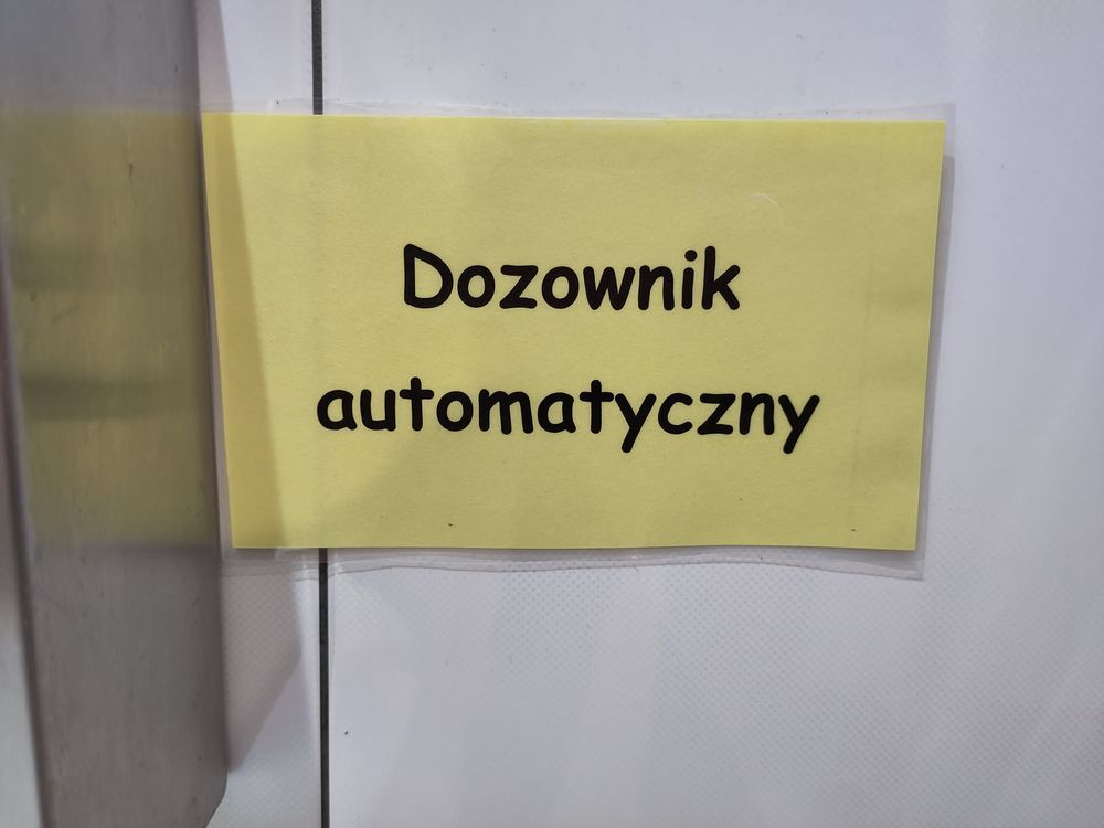 Zdjęcie żółtej, zalaminowej kartki, na który napisane jest Comic Sansem "Dozownik automatyczny"