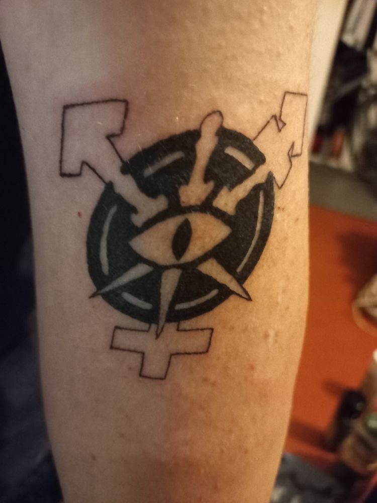 A tattoo on my upper arm.
It is a symbol with 3 blades crossed over an eye inside a circle that serves as the center for the trans symbol