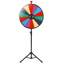 This image shows a wheel on a vertical stand. The wheel has several sections of different colors and directional arrows that indicate to “spin” the wheel either direction. 