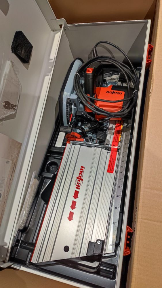 Kappschienensäge von Mafell im Koffer mit geöffnetem Deckel. Dieser steht wiederum im Versandkarton.