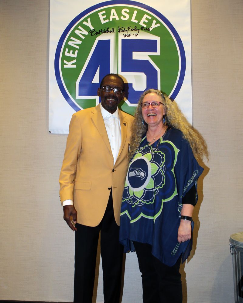 Photo with me and Kenny Easley in 2019.  He was truly a Seahawk legend and such a nice man.  We are standing side by side, him in his gold jacket and me in my Seahawk tunic, both smiling.