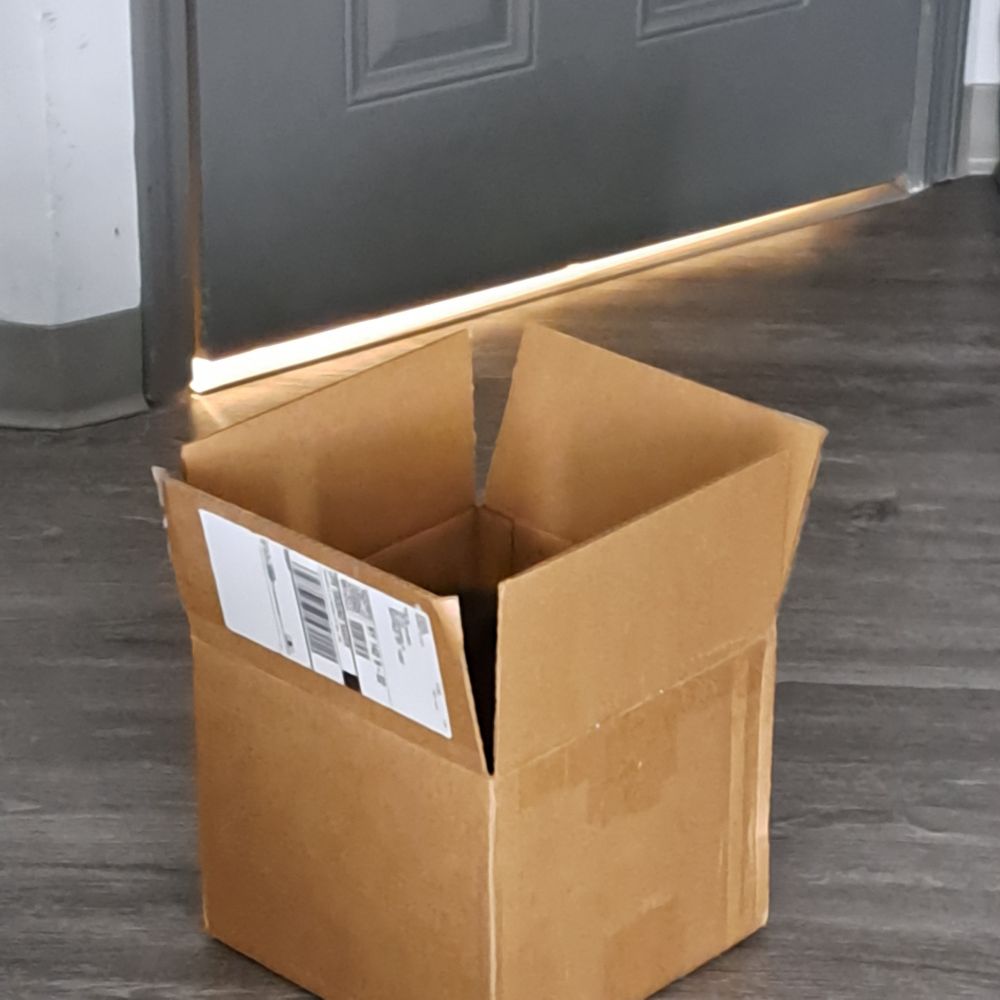 Photoof a square cardboard box with its flaps open.