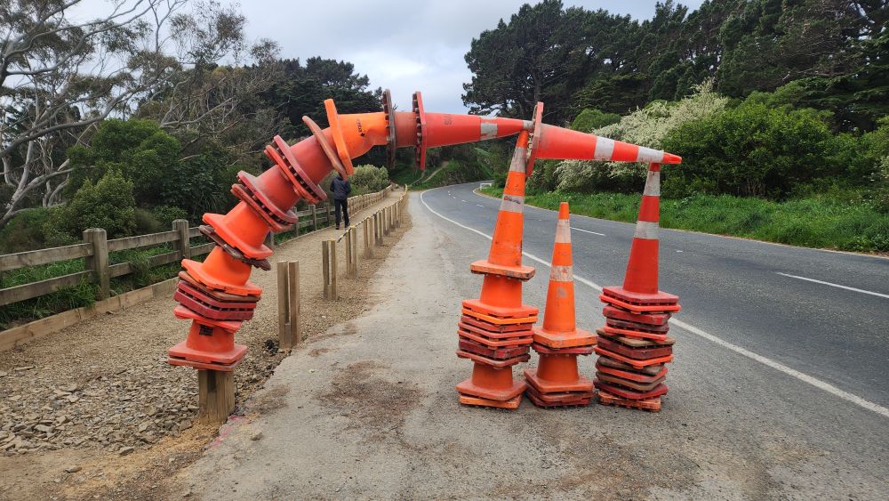 Photo of a pile of orange road cones arranged in a striking arc