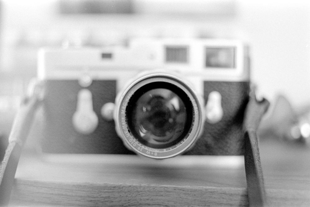 This is a black & white photo of my Leica M2. I recently bought a used Nikkor 85mm for the Nikon bodies and was testing it on the F2 body. This image is a frame near the beginning from that test roll. 

When the roll is finished, I have begun the habit of winding the film such that the tag end remains out of the cassette. I finished shooting the test roll and began winding. I thought I felt the tug of the tag pulling out of the take up spool, so I gave it another half turn and popped open the film door. To my surprise, there was still film spooled and I slammed the door closed as quickly as I could. I started winding once again, not knowing exactly how many frames I’d ruined.

After I developed the film, I found that there were 3 frames completely gone from that silly muck up, plus several that had been slightly exposed to the light. This one, the second frame on the roll, was one that had light leak but ultimately turned out better than what I think it would have without the leak.