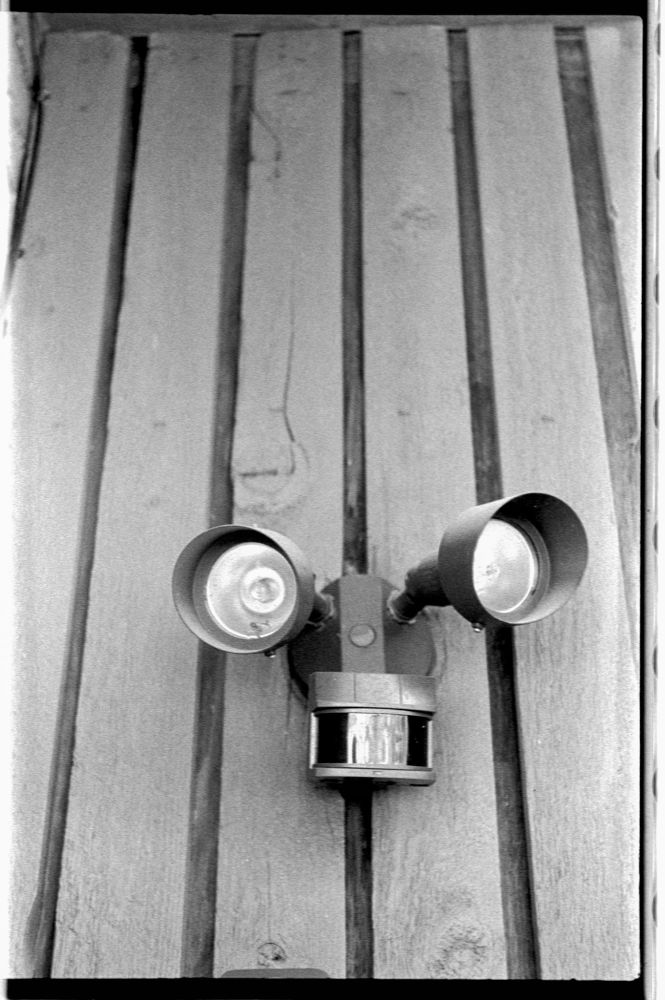 I turned and looked at the wall, the wooden shiplap-like siding stretching to the roof line. There before me was what appeared to be a robot’s head mounted on the wall like a hunter’s moose trophy. Its eyes bulged on little antenna posts; its mouth in between an absurd smile and a moment of surprise.

In that instance I blinked and it all came into focus—my flood lamp and motion sensor had once again got the better of my imagination.