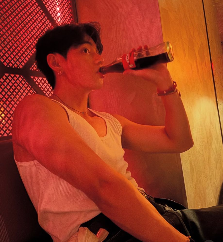 Teaching drinking what might be a glass Coke but I don’t have my glasses on and it’s almost 3 am and im more concerned about him wearing a white tank like as if im a Victorian maiden scandalized by naked arms 